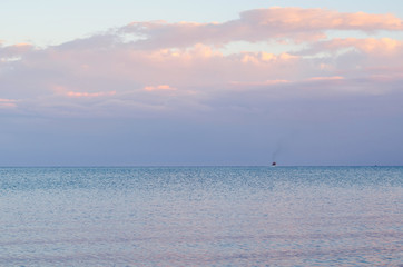 Fototapeta premium Calm sea, the cargo ship in the distance on the horizon