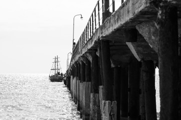 Sailing ship near the pier. Black and white photo.