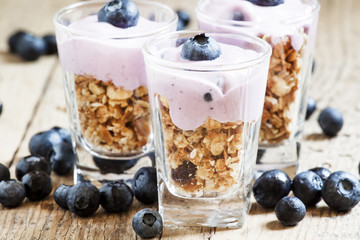 Homemade baked granola with yogurt and blueberries in a glass an