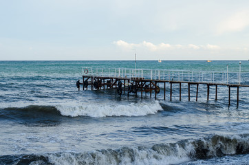 The raging sea and wooden jetty.