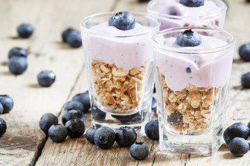 Homemade baked granola with yogurt and blueberries in a glass an