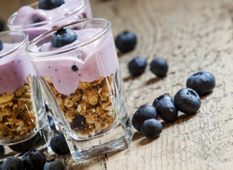 Homemade baked granola with yogurt and blueberries in a glass an