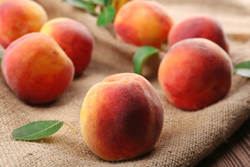Fototapeta na wymiar Fresh peaches on sackcloth, closeup