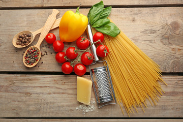 Pasta spaghetti with tomatoes, cheese and basil on rustic wooden  background