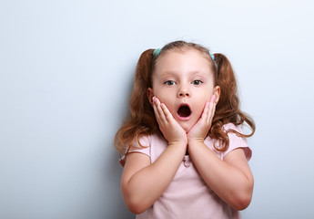 Fun surprising kid girl with opened mouth looking