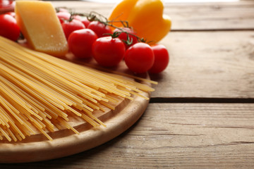 Pasta spaghetti with tomatoes, cheese and basil on rustic wooden  background