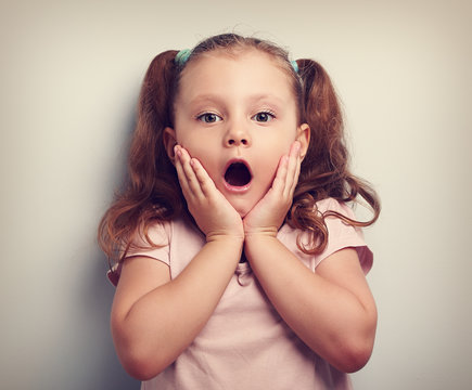 Fun surprising kid girl with opened mouth looking. Toned portrai