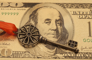Key To Success With Red Bow on Golden hundred dollar bill