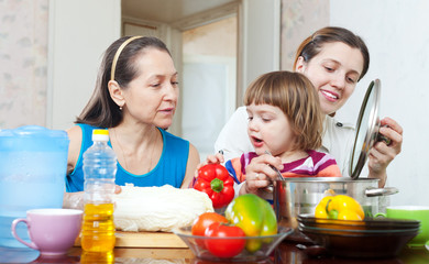  women with baby girl cook with vegetables