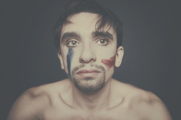 Portrait of beautiful young man with paint on his face