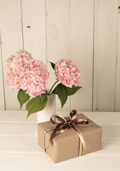 Hortense in vase and gift box on wooden board