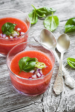 gazpacho in a glass bowl on a light wooden background
