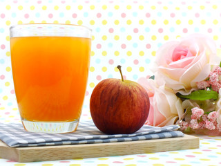 orange juice and red apple on sweet polka dot background