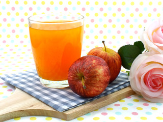orange juice and red apple on sweet polka dot background