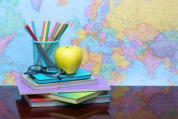 Back to school concept. An apple, colored pencils and glasses 