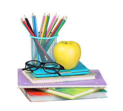 Back to school. An apple, colored pencils and glasses on pile 

