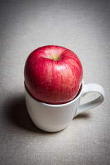 an apple on a cup