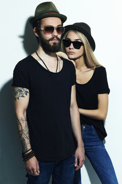 fashion beautiful couple in hat together. Hipster boy and girl.tattoo