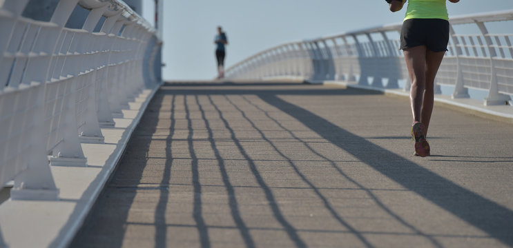 Women running on urban footbridge, Bordeaux, France