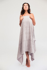 Thoughtful woman standing in towel