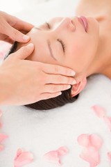 Obraz na płótnie Canvas Attractive young woman receiving facial massage 