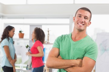 Obraz premium Casual male artist with colleagues in background at office