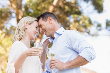 Smiling couple holding wine and looking intensively at each other