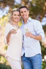 Portrait of smiling couple embracing and holding wineglass