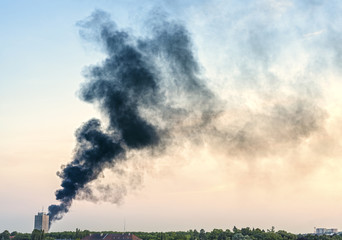 Smoke from a fire above city at sunset, Szczecin, Poland.