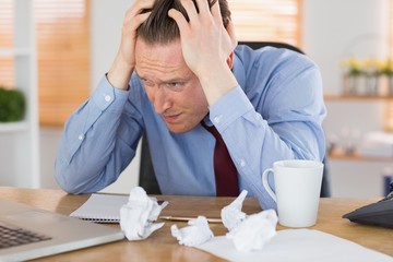 Stressed businessman with head in hands