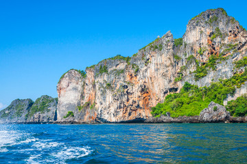 Cliff and the clear sea with a boat near Phi Phi island in south