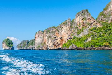 Cliff and the clear sea with a boat near Phi Phi island in south