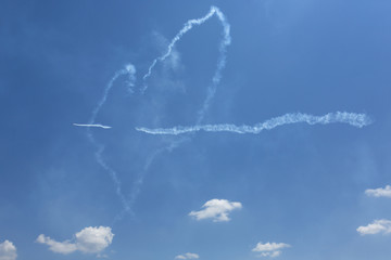 Show of airplanes creating smoke trails in the shape of a heart