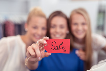 frauen beim einkaufsbummel zeigen sale-schild