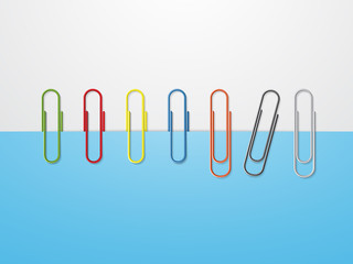 Colorful paper clips on blue paper