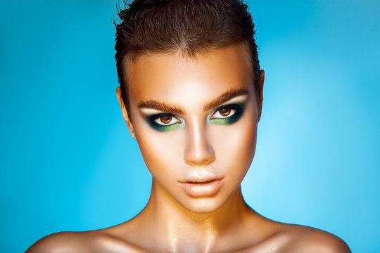 Fashionable young girl with green colors makeup and short hairst