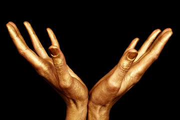 Two male hands in gold paint isolated