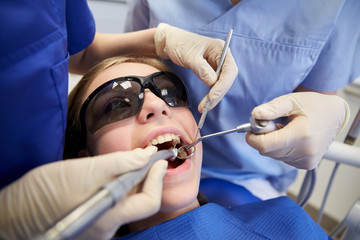 Fototapeta premium female dentists treating patient girl teeth