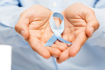 hands with blue prostate cancer awareness ribbon