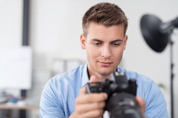 junger mann mit einer fotokamera im studio