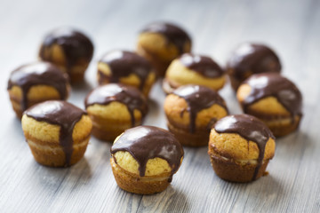 Cupcakes with vanilla cream and chocolate topping on grey wood stand