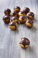 Cupcakes with vanilla cream and chocolate topping on grey wood stand