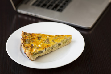 Delicious eggplant savory tart with goat cheese served on a wooden board at lunch