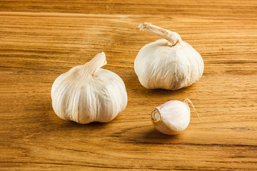 Whole and clove of garlic on a wooden table