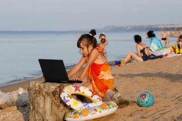 Девочка с ноутбуком на пляже