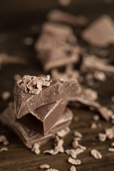 Broken chocolate bar on wooden background, close-up