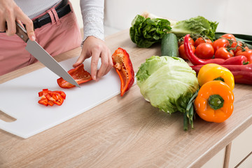 Woman Chopping Chili Pepper With Knife