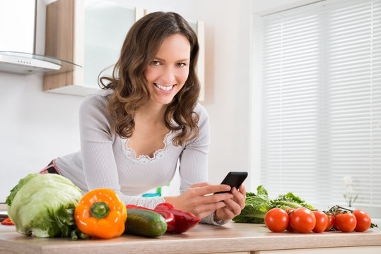 Woman Smiling While Using Mobile Phone