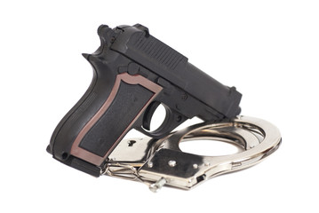 Obraz premium Gun and handcuffs isolated on white background
