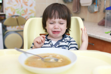 Fototapeta na wymiar Crying child dont want to eat soup